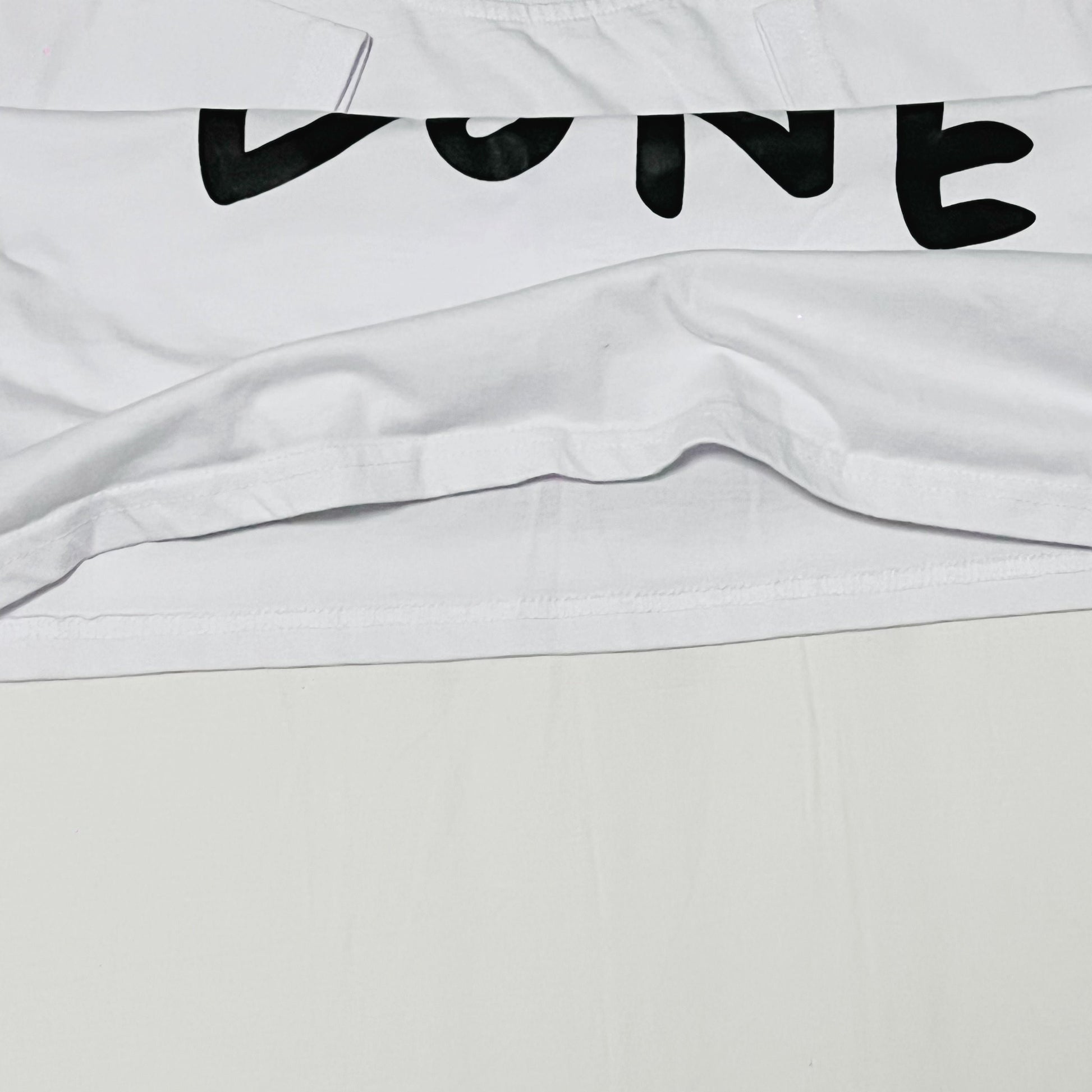 short sleeve white t-shirt with get shit done print clost-up image of the stitching